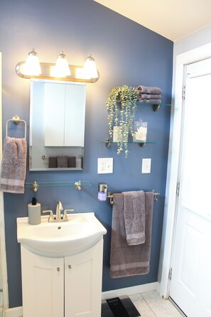 A bathroom with a white sink, a mirror, and a towel rack. - Long Lake Retreat (Lacey)