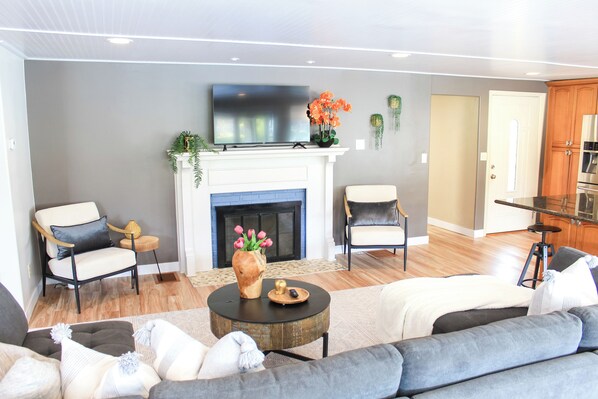 A modern living room with a fireplace, a television, and comfortable seating.
