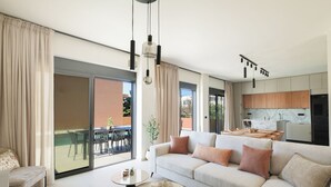 A modern living room with a sofa, a coffee table, and a dining area with chairs and a table.