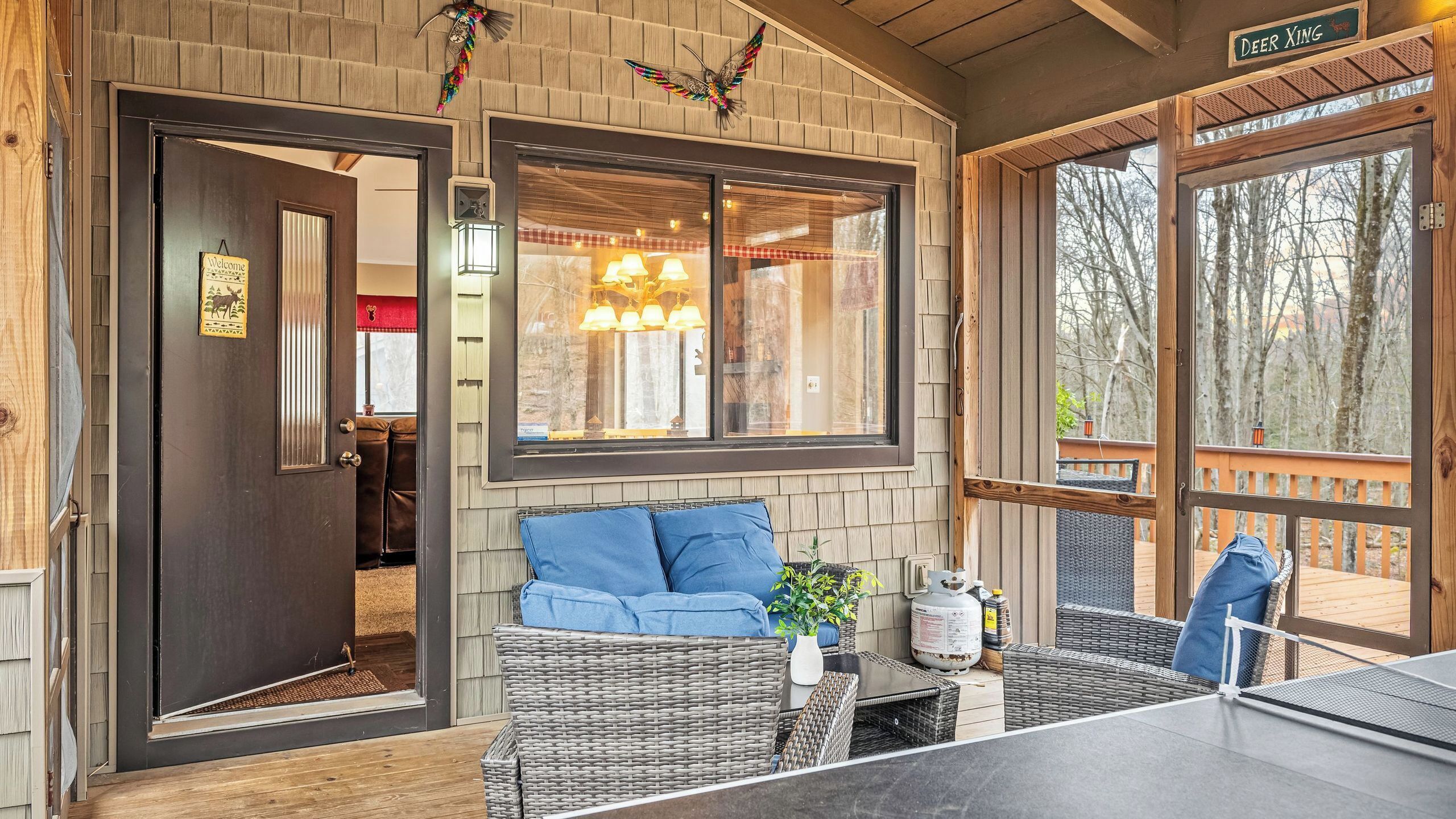 A wooden exterior with a door, windows, and a sign reading 'Deer Xing.'