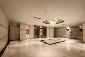 A spacious lobby with a central chandelier, elevators, and a reception desk. - Jintan Square South Great Wall Hotel (Tongren Station Branch) (Tongren)