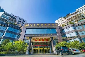 A multi-story building with a prominent entrance, large windows, and a clear sky.