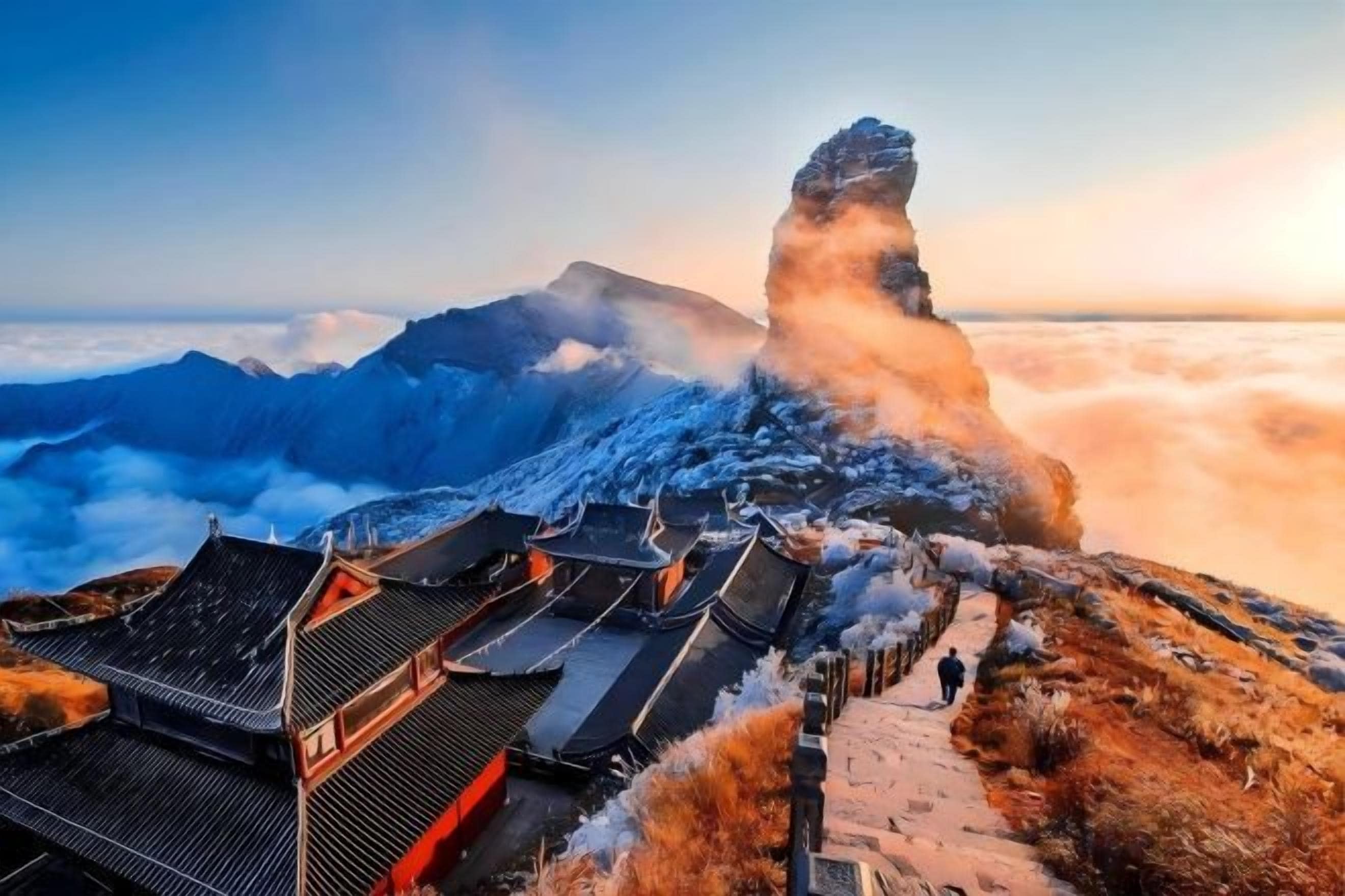 A traditional building with a steep roof, surrounded by snow-covered terrain and a prominent rock formation.