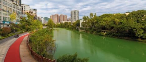 Un río con una pasarela de madera y un sendero rojo a su lado.