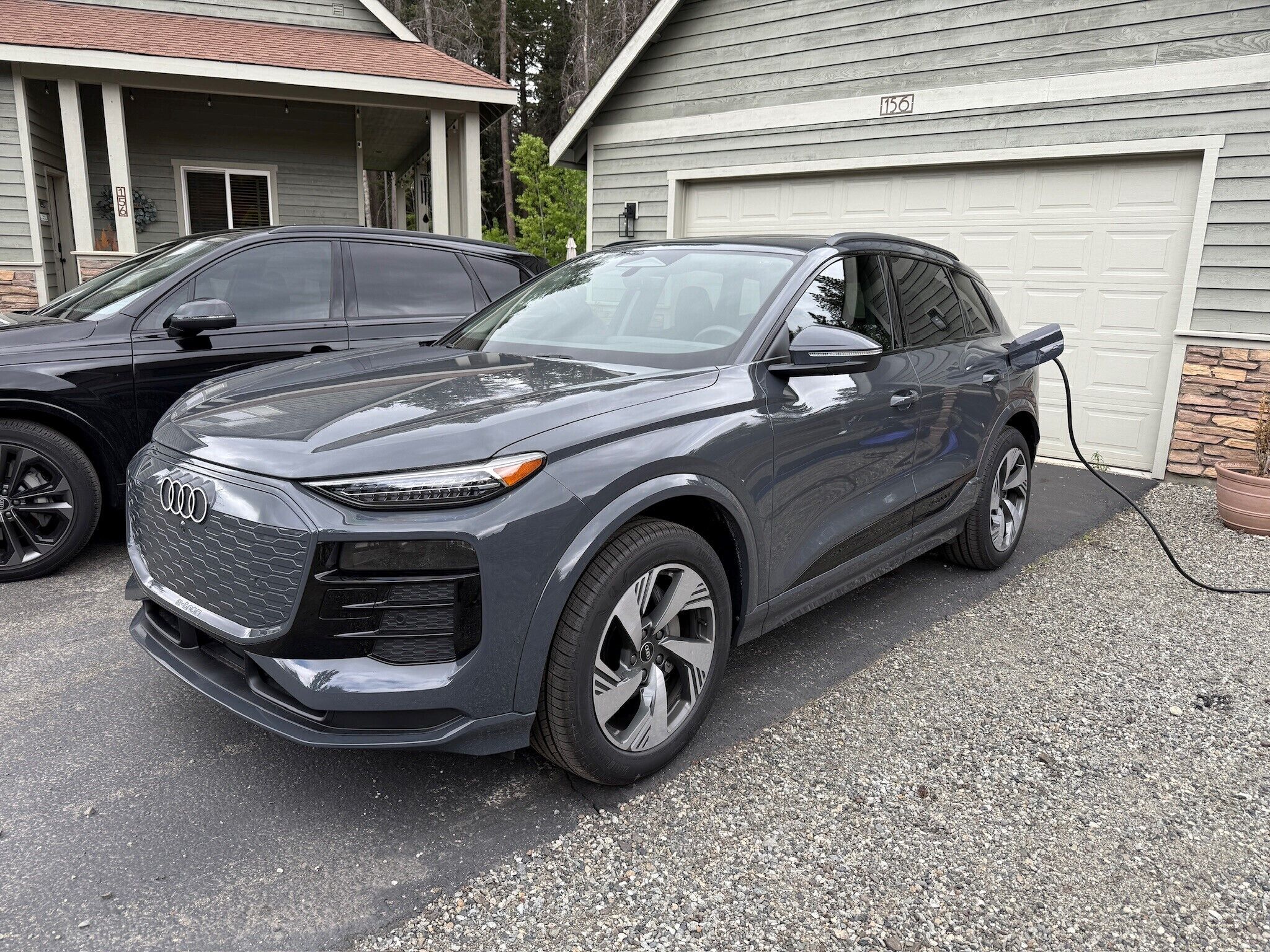 A dark-colored SUV parked in a driveway with a garage in the background.