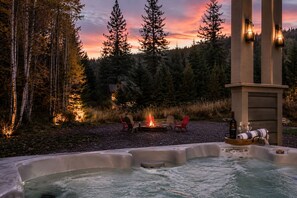 A hot tub with a fire pit and chairs in a forested area. - Roslyn Hideaway - Lake Fun, Games, Hot Tub (Ronald)