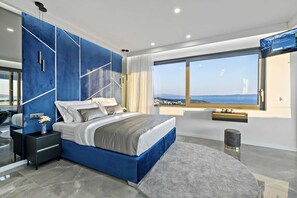 A modern bedroom with a large bed, a view of the sea, and a large window. - Villa Mosaicus with Pool (Makarska)