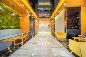 A lobby with a green wall, seating area, and a reception desk. - Haoshidai Hotel (Nanning Jiangnan Passenger Station Jinxiang Avenue Subway Station) (Nanning)