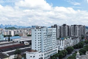 A high-rise building with multiple floors, surrounded by other buildings and greenery.