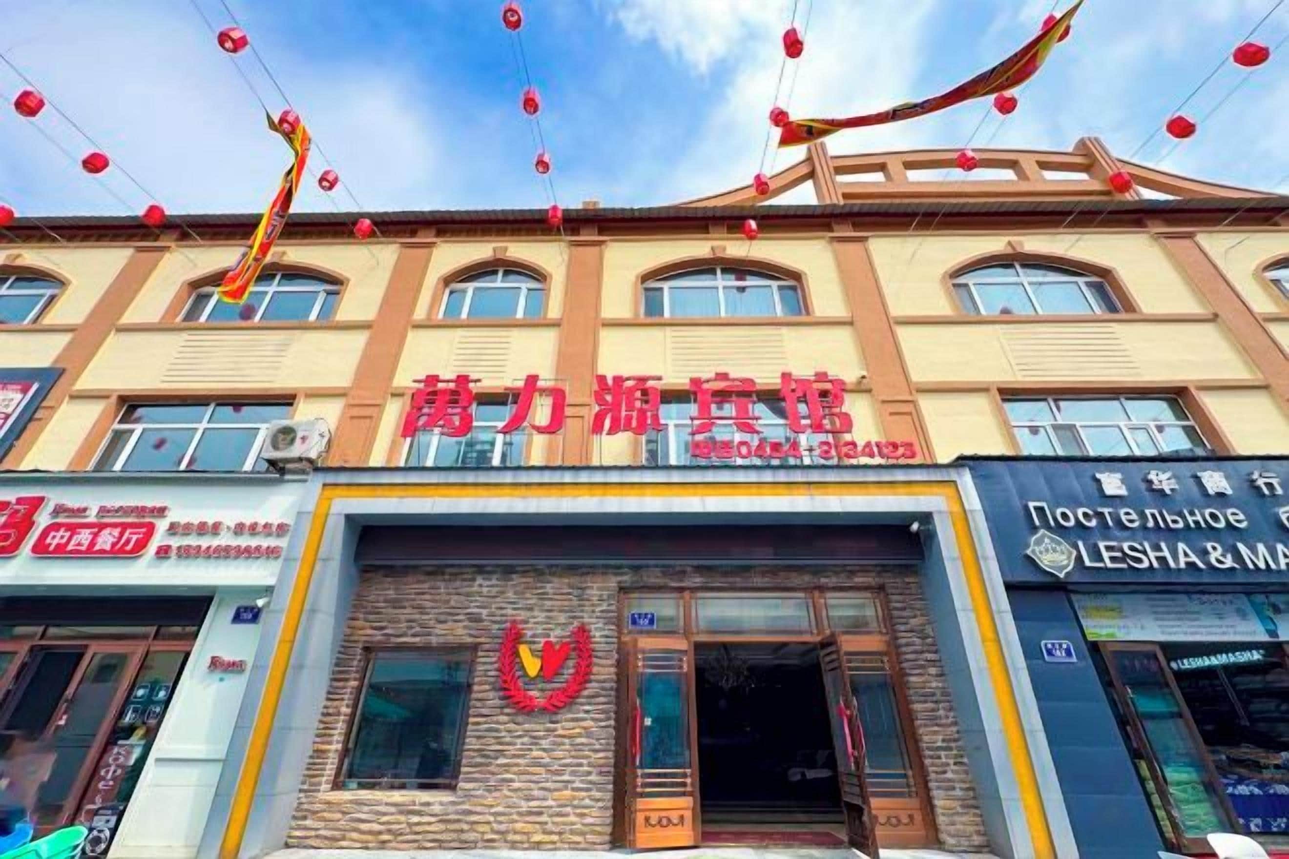 A building with multiple storefronts, including one with a prominent red sign.