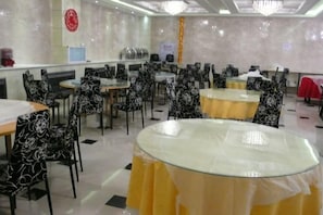 A banquet hall with round tables, chairs, and a chandelier. - Wanliyuan Hotel (Fuyuan)