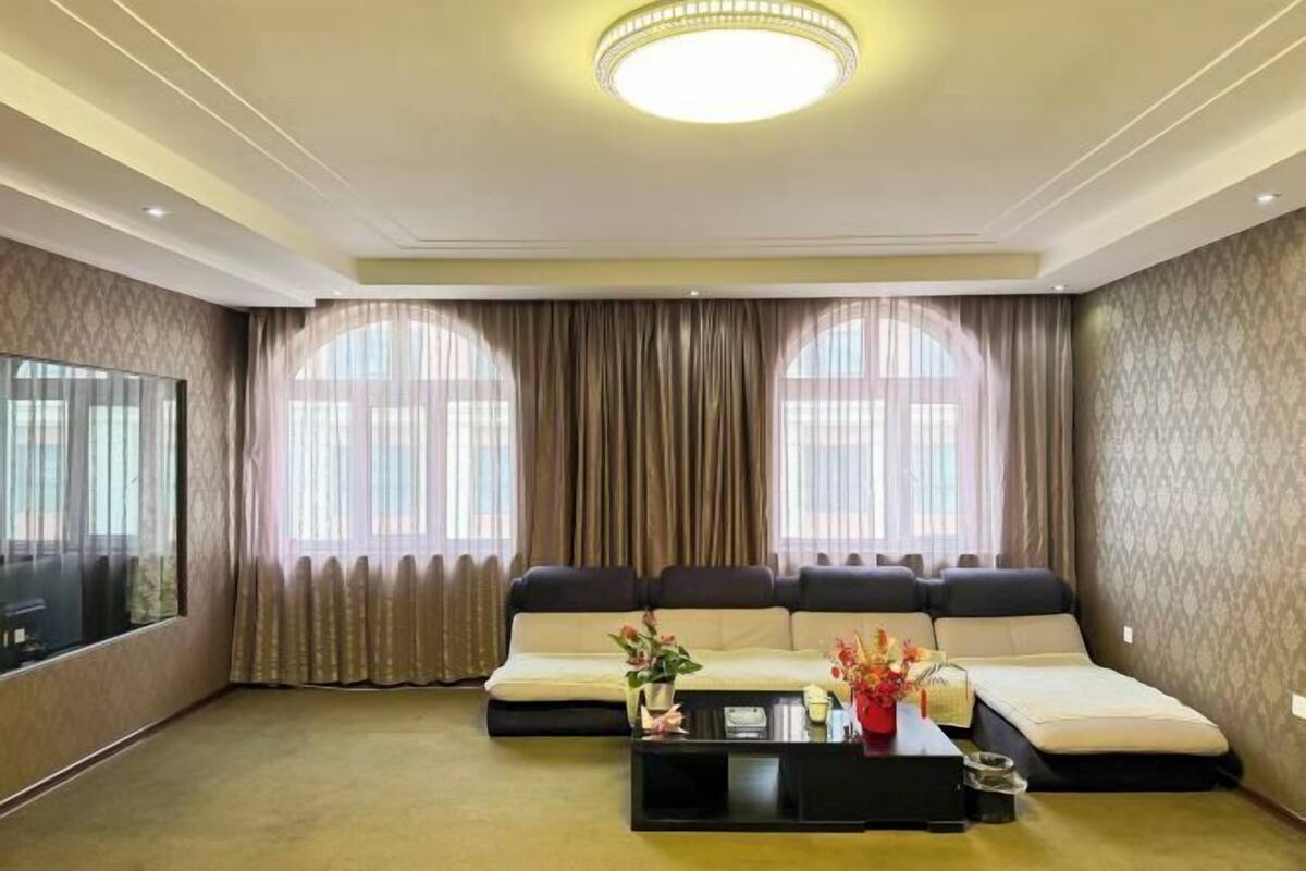 Uma sala de estar com sofá, mesa de centro e televisão.