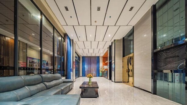 A modern lobby with a leather sofa, a coffee table with flowers, and a glass wall. - Tiancheng Business Hotel (Pingxiang Railway Station) (Pingxiang)