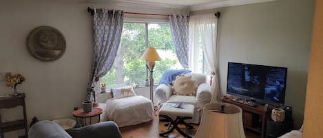Relax in a spacious living room with a sofa, armchair, and large window.