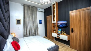 Una camera da letto moderna con un letto grande, una TV fissata a una parete in legno e un armadio.