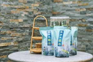 Une table avec des sachets de thé et un panier en osier, le tout adossé à un mur de pierre.