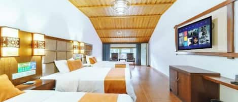 Camera d'albergo con due letti, soffitto in legno e televisione a parete.