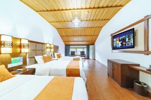 Habitación de hotel con dos camas, techo de madera y televisión en la pared.