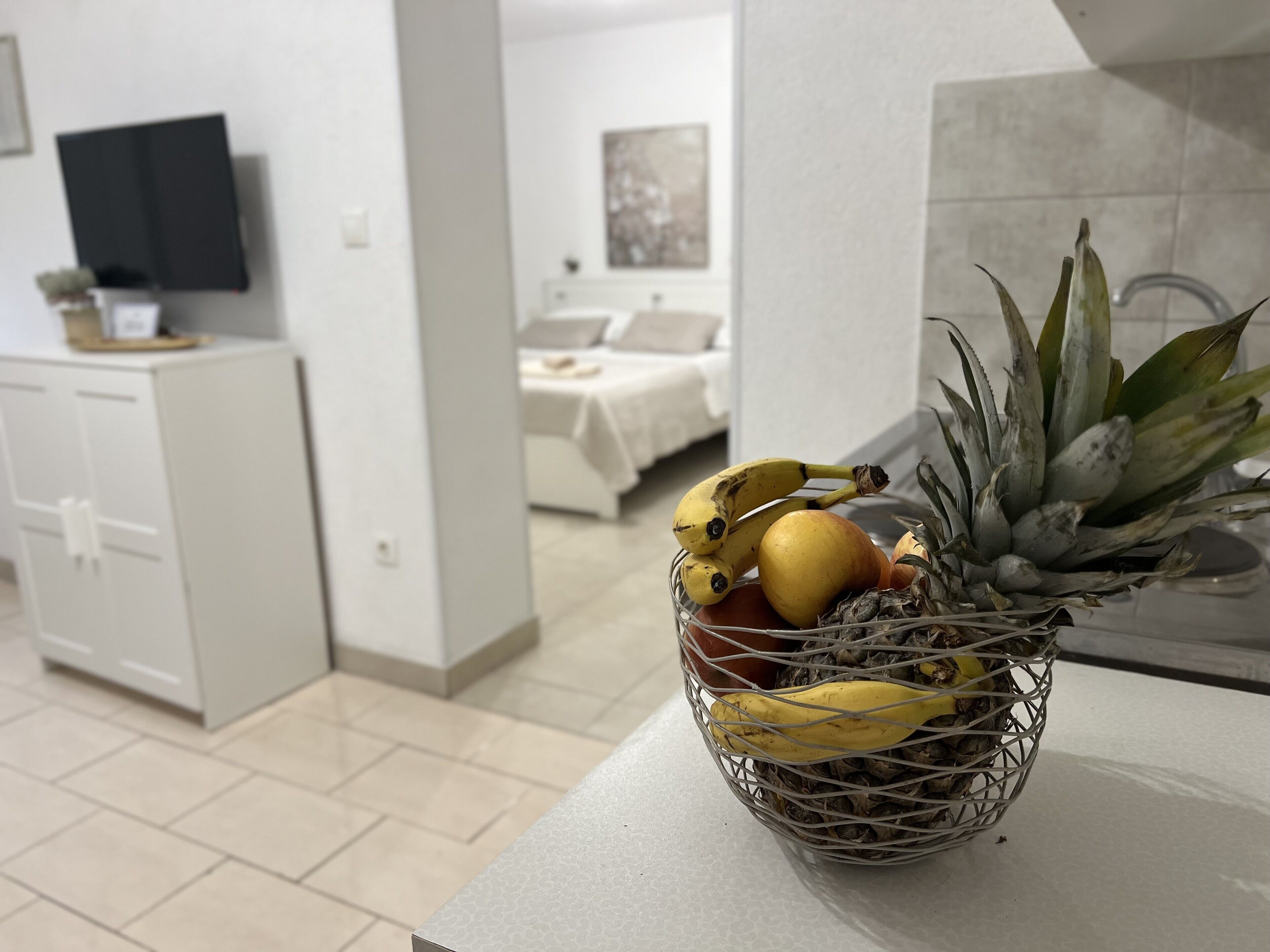 Una moderna camera d'albergo con angolo cottura, un tavolo da pranzo e un letto.