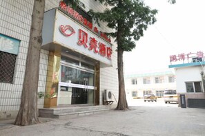 A building with a storefront featuring a sign with Chinese characters. - Shell Hotel (Zhaoyuan Wenquan Road) (Zhaoyuan)