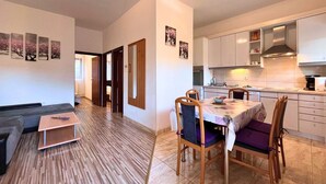 A modern apartment with a dining area, kitchen, and living room.