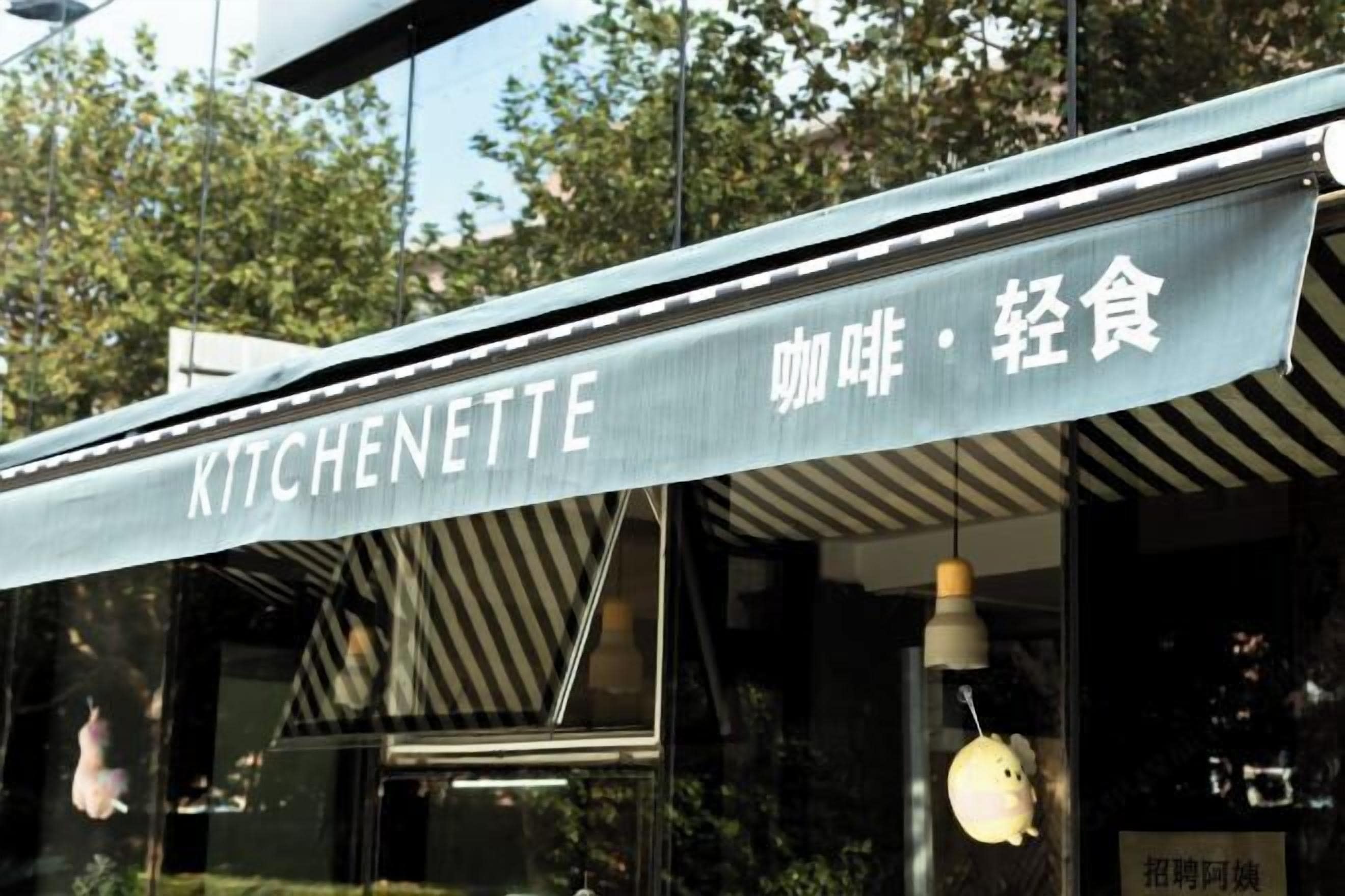 A restaurant sign with the name "KITCHENETTE" and Chinese characters for "snack" and "light food".