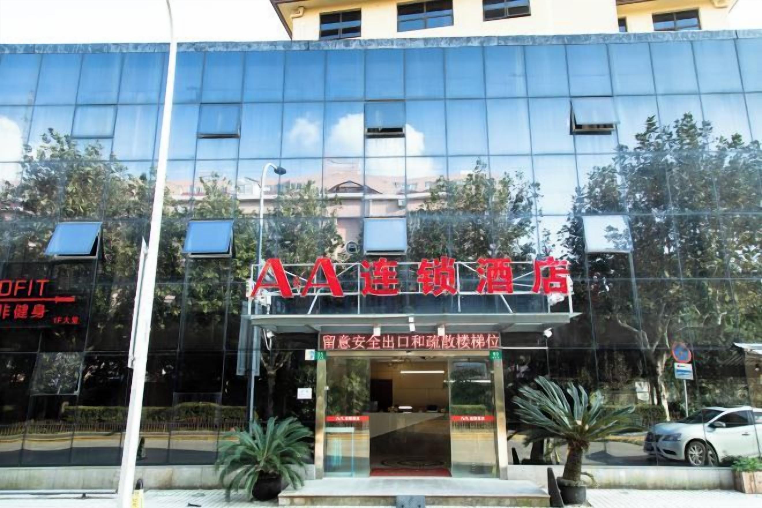 A hotel with a modern glass facade and a red sign indicating it is a hotel.