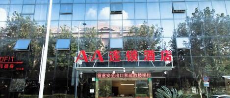 A hotel with a modern glass facade and a red sign indicating it is a hotel.