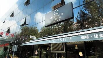 A modern building with a sign for 'KITCHENETTE' and a storefront with a similar name.