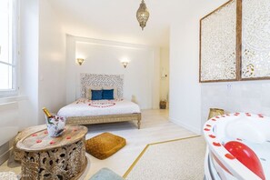 Quarto com cama, mesa de cabeceira e painel decorativo na parede.