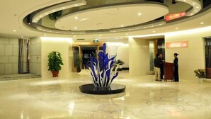 A modern lobby with a central decorative fountain, a reception desk, and a polished marble floor. - Solar Valley Micro-E International Hotel (Dezhou)