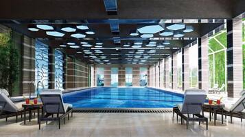 Piscina com espreguiçadeiras, piso em mosaico e teto com padrões geométricos.