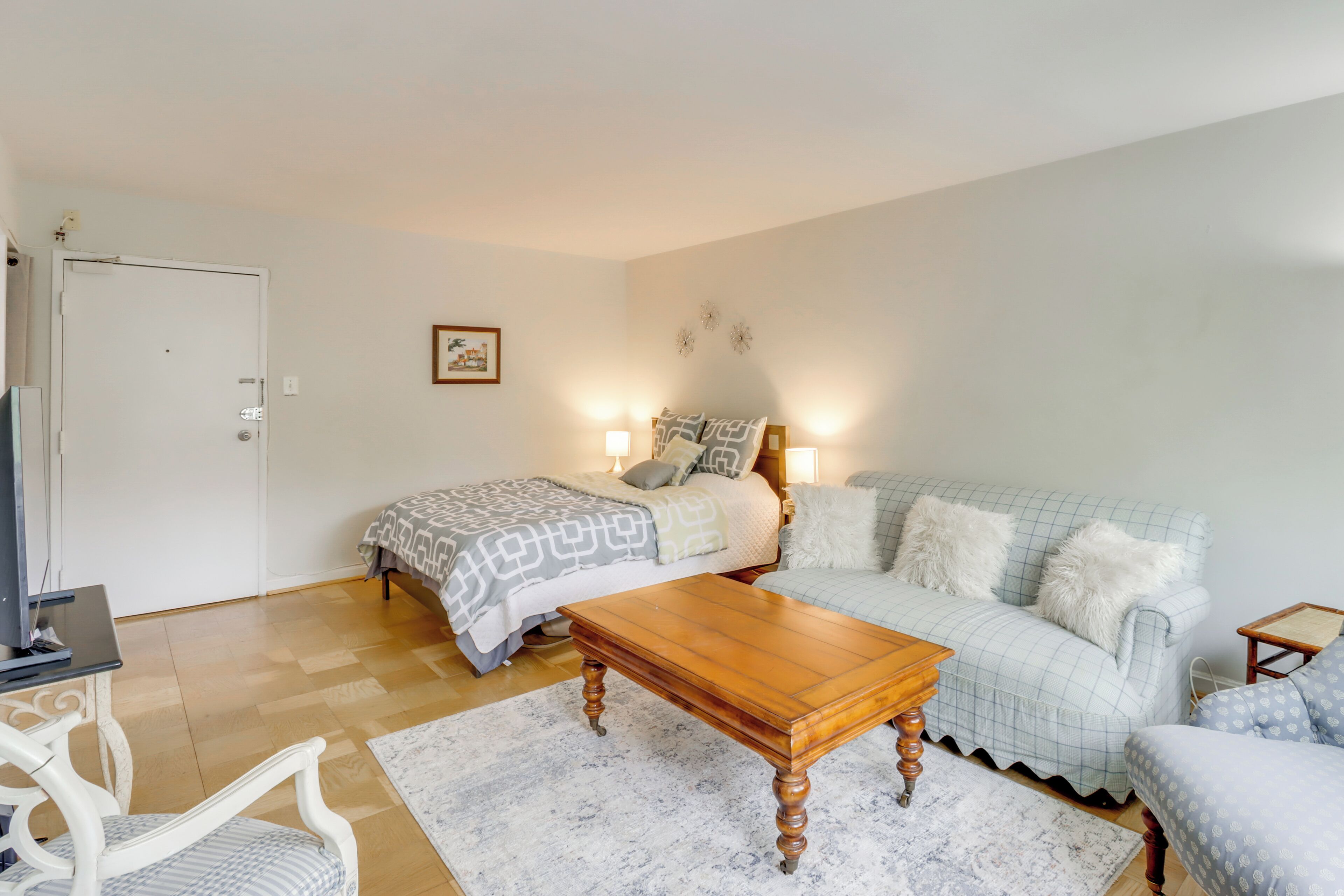 Une chambre à coucher comprenant un lit, une table basse en bois, un canapé, une chaise et une petite table avec une lampe.