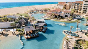 Ein Resort mit einem zentralen Pool, mehreren Gästevillen und einem Strand.