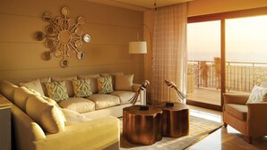 Ein geräumiges Wohnzimmer mit einer großen Couch, einem Couchtisch und einem Balkon mit Meerblick.