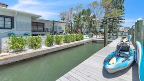Un puerto deportivo con un muelle, un kayak y un pequeño edificio con un letrero que dice 