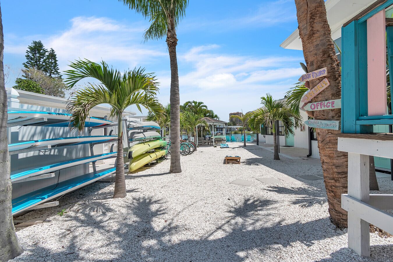 A beachside area with kayaks and a paddleboard rental sign, a pool, and a building labeled "Office".