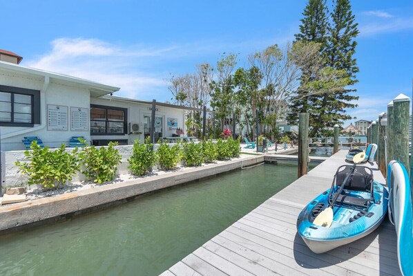 Un port de plaisance avec un quai, un kayak et un petit bâtiment sur lequel est apposée une enseigne indiquant « Bureau ».