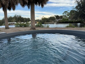 A swimming pool with a view of a lake and trees. - Resting Place of Treasure Island NPR Waterfront Retreat w/ Kayaks & Sunroom (New Port Richey)