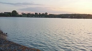 Une vue sur le bord de l’eau, avec un mur de pierre et une eau calme.
