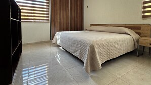 Una camera da letto con un letto, un armadio e una TV.
