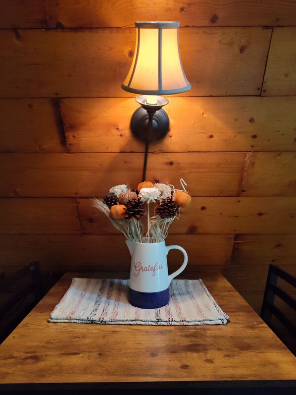 Une table sur laquelle se trouve une tasse blanche portant l’inscription « Grateful » et une lampe.