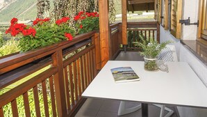 Un balcon avec une table blanche, un magazine et une plante en pot.