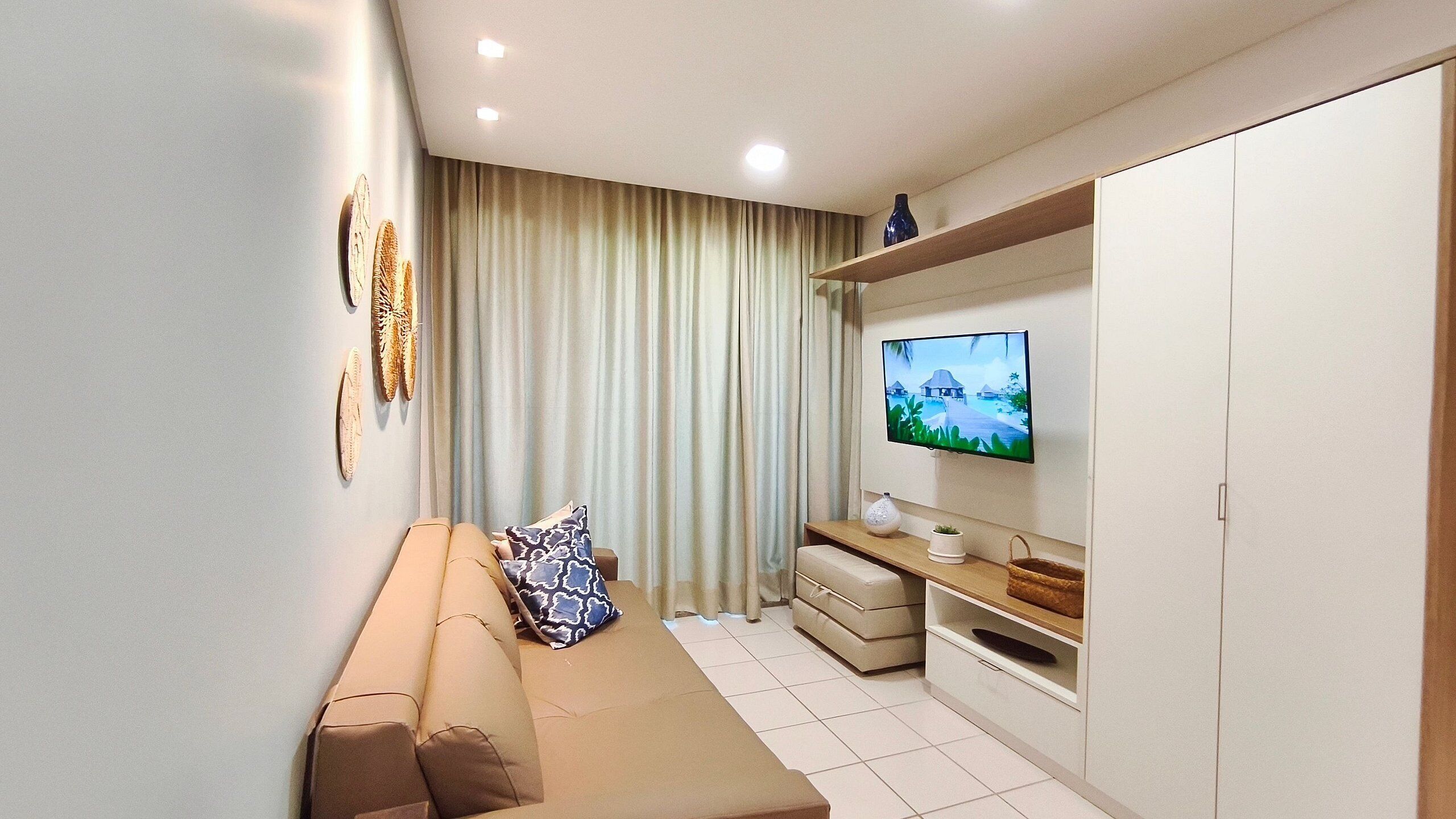 A modern living room with a sofa, TV, and a curtain.