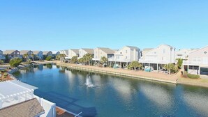 Zona residencial junto al agua, con casas a lo largo de un canal, que incluye un paseo peatonal y un pequeño embarcadero.