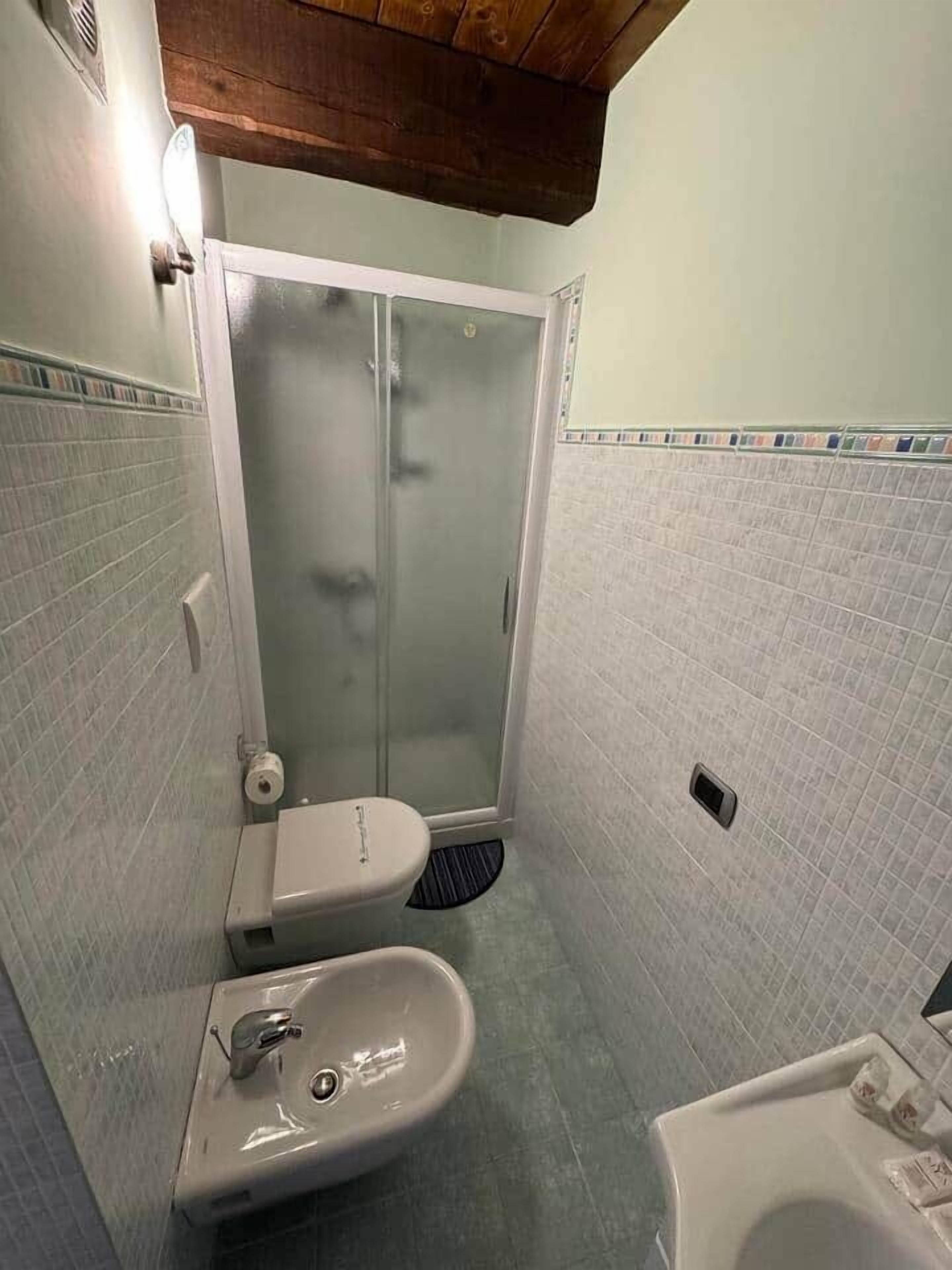 Un baño pequeño con inodoro, bidé y lavamanos.