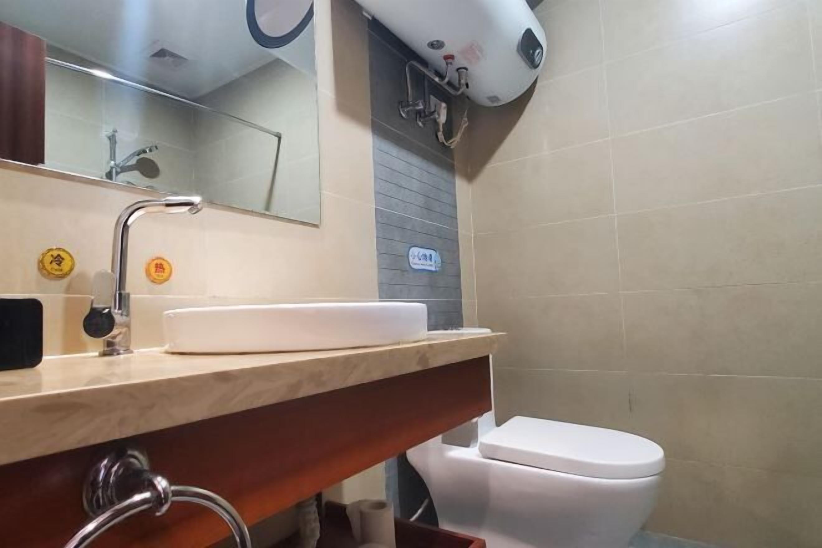 A bathroom with a sink, mirror, towel rack, and toilet.