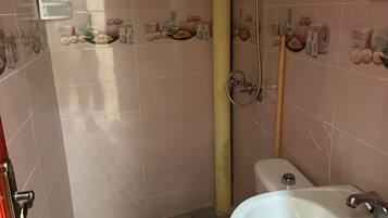 A bathroom with a toilet, sink, and shower.
