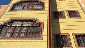 Un immeuble à plusieurs étages doté de grandes fenêtres ornées de barreaux en métal.