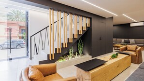 Una sala de estar moderna con un sofá, una mesa de centro y una escalera con barandillas de madera.